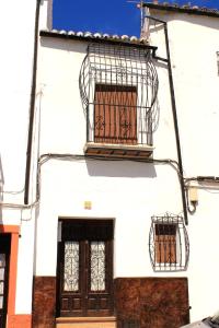 隆达Typical Andalusian house in the center of Ronda / Casa típica andaluza en el centro de Ronda.的一座白色的建筑,上面有鸟笼