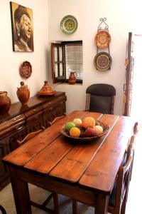 隆达Typical Andalusian house in the center of Ronda / Casa típica andaluza en el centro de Ronda.的一张木桌,上面放着一碗水果