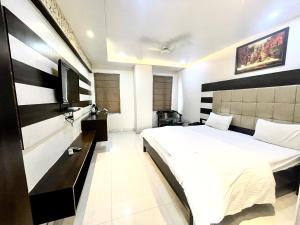 瓦拉纳西HOTEL P PALACE ! VARANASI fully-Air-Conditioned-hotel lift-and-Parking-availability, near Kashi Vishwanath Temple, and Ganga ghat的卧室配有白色的床和电视。