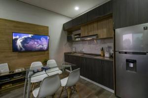 瓦兹特佩克Sierra Apartments Estudios en Oaxtepec的一间带餐桌的厨房和一台墙上的电视