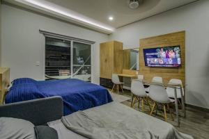 瓦兹特佩克Sierra Apartments Estudios en Oaxtepec的卧室配有一张床和一张桌子及椅子