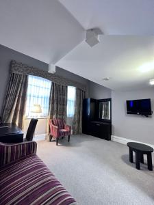德比Cathedral Quarter Hotel - Derby的一间卧室配有一张床、一台电视和一张沙发