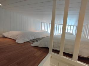 博尔斯塔Bålsta Studio Houses的一间卧室配有一张铺有木地板的白色床单。
