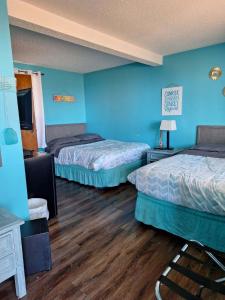 马布尔黑德Lake Point Motel的配有蓝色墙壁和木地板的客房中的两张床