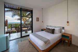 图卢姆Tropicalito Villa on the Beach的一间卧室设有一张床,享有海景