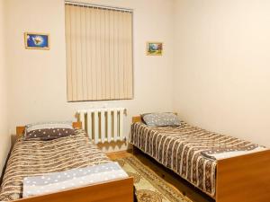 卡希Guliyev Home的一间卧室设有两张床、一个窗户和散热器