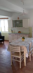 科里纳尔多nonna Ledi centro storico的厨房配有白色的桌子和桌椅