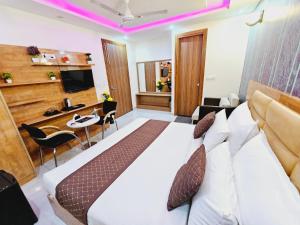 新德里Hotel tu casa International Near Delhi Airport的酒店客房设有一张大床和一张书桌。