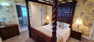 廷塔杰尔卡米洛城堡酒店的一间卧室配有一张天蓬床和两盏灯。