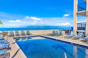 拉海纳卡哈纳海滩度假俱乐部酒店的一个带椅子的游泳池,背景是大海
