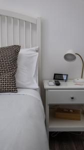 锡拉库扎Central Perk的一间卧室配有一张床和一个带灯的床头柜