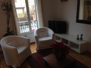 马拉科夫小房子公寓的客厅配有两把椅子和电视