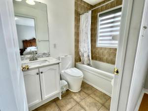 多伦多House In Scarborough 20 Minutes to Downtown的浴室配有盥洗盆、卫生间和浴缸。
