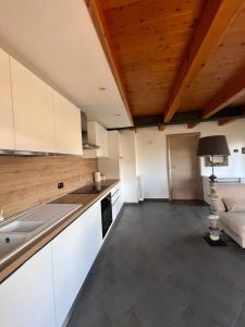 奥斯塔Grazioso appartamento的厨房配有白色橱柜和木制天花板