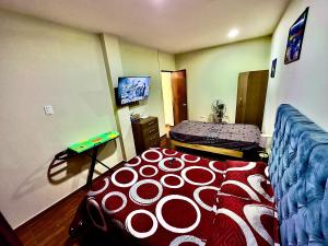 利马100- departamento céntrico en chorrillos的一间卧室配有一张带红色和白色棉被的床