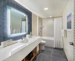 檀香山Renaissance Honolulu Hotel & Spa的一间带两个盥洗盆、浴缸和卫生间的浴室