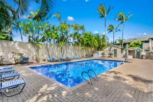 拉海纳西毛伊岛花园酒店的一个带椅子的游泳池,棕榈树