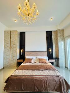 尼甘布Grand Sri Lounge - Ocean Breeze Hotel residents的一间卧室配有一张大床和一个吊灯。