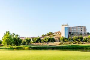维拉马约多娜布里吉达萨拉曼卡论坛酒店的一座以建筑为背景的高尔夫绿地