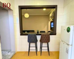 布赖代البندقية للخدمات الفندقية BQ HOTEL SUITES的厨房配有2把吧台凳和1面镜子