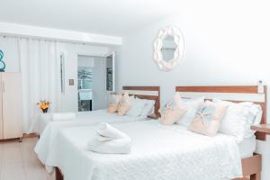 圣安德烈斯APARTAHOTEL BEIRUT INN的配有白色和粉红色枕头的客房内的两张床