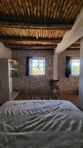 AghnajaneMomo's beach house的一间卧室设有一张大床和两个窗户。