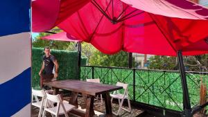 蒙得维的亚Loft casa dos pisos con garage pocitos playa 4 personas的站在桌子旁,拿着两把大伞的人