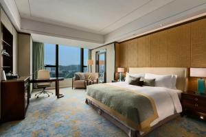 厦门厦门源昌凯宾斯基大酒店的酒店客房设有一张大床和一张书桌。