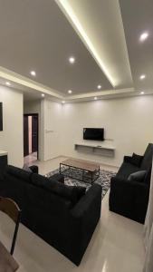 阿哈达نايس فور الهدا的客厅配有两张黑色沙发和一台电视机