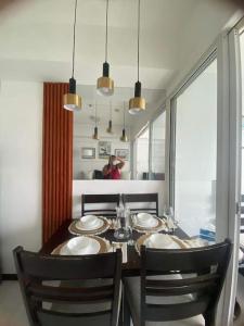 马尼拉Azure Beach view near airport的一间带桌椅和窗户的用餐室