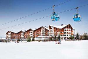 班斯科Kempinski Hotel Grand Arena Bansko的雪地滑雪胜地,带滑雪缆车