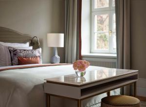 德累斯顿塔森博格帕莱凯宾斯基酒店的一间卧室配有一张床和一张鲜花桌子