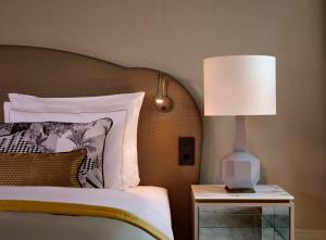 德累斯顿塔森博格帕莱凯宾斯基酒店的一间卧室,配有一张带台灯的床头柜