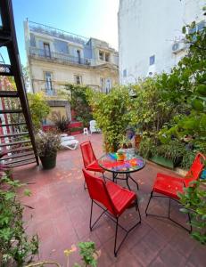布宜诺斯艾利斯LGY G A Y Bed & Breakfast ONLY MEN的庭院配有红色的椅子和桌子