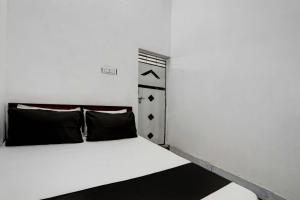 JhājharOYO New River View的卧室配有带黑色枕头的白色床