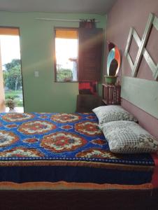 穆隆古Colina dos Ventos的一间卧室,床上有五颜六色的被子