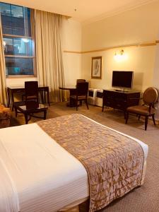 布里斯班皇家阿尔伯特酒店 的酒店客房,配有床和电视