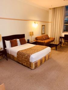 布里斯班皇家阿尔伯特酒店 的酒店客房,配有床和沙发