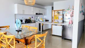 蓬塔赫尔莫萨Apartamento Playa Señoritas的厨房配有玻璃桌和冰箱