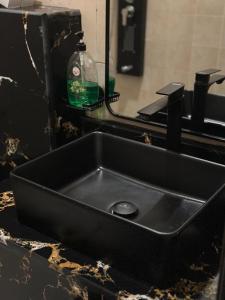 Al Nairyahشقق ارجان نجد المفروشه的浴室内的一个黑色水槽,配有镜子