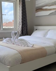 伯明翰Tayy’s Inn的一间卧室,床上配有2条天鹅毛巾