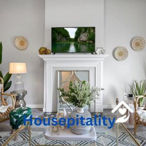 哥伦布Housepitality - The Olive - 4 BR 2 Bath的客厅设有壁炉,上面配有电视