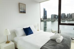 墨尔本Pars Apartments - Collins Wharf Waterfront, Docklands的卧室设有一张白色大床和大窗户