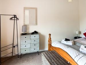 库姆马丁Roseus - Uk44706的一间卧室配有一张床和一个带镜子的梳妆台
