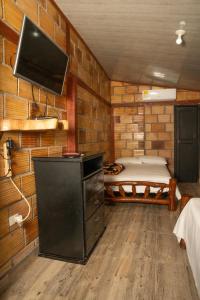 圣何塞德尔瓜维亚雷Posada Campestre Ecoturística Granja Julieth的客房设有一张床和一台平面电视。