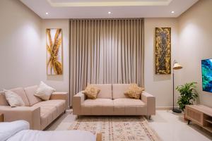 利雅德New Studio With Boho style *Centre of Riyadh*的客厅配有两张沙发和一台电视机