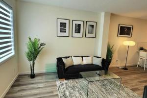 埃德蒙顿Modern entire 3 bedroom home in downtown Edmonton的客厅配有黑色沙发和玻璃桌