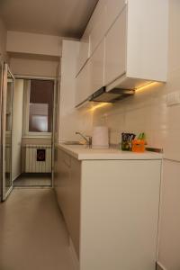沙巴茨Apartment Venera A&M的厨房配有白色橱柜和水槽