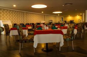 巴统Orbi City Hotel Batumi Beach View的一间设有红色和白色桌椅的用餐室
