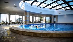 巴统Orbi Hotel City Batumi的在大楼里的大型游泳池游泳的人